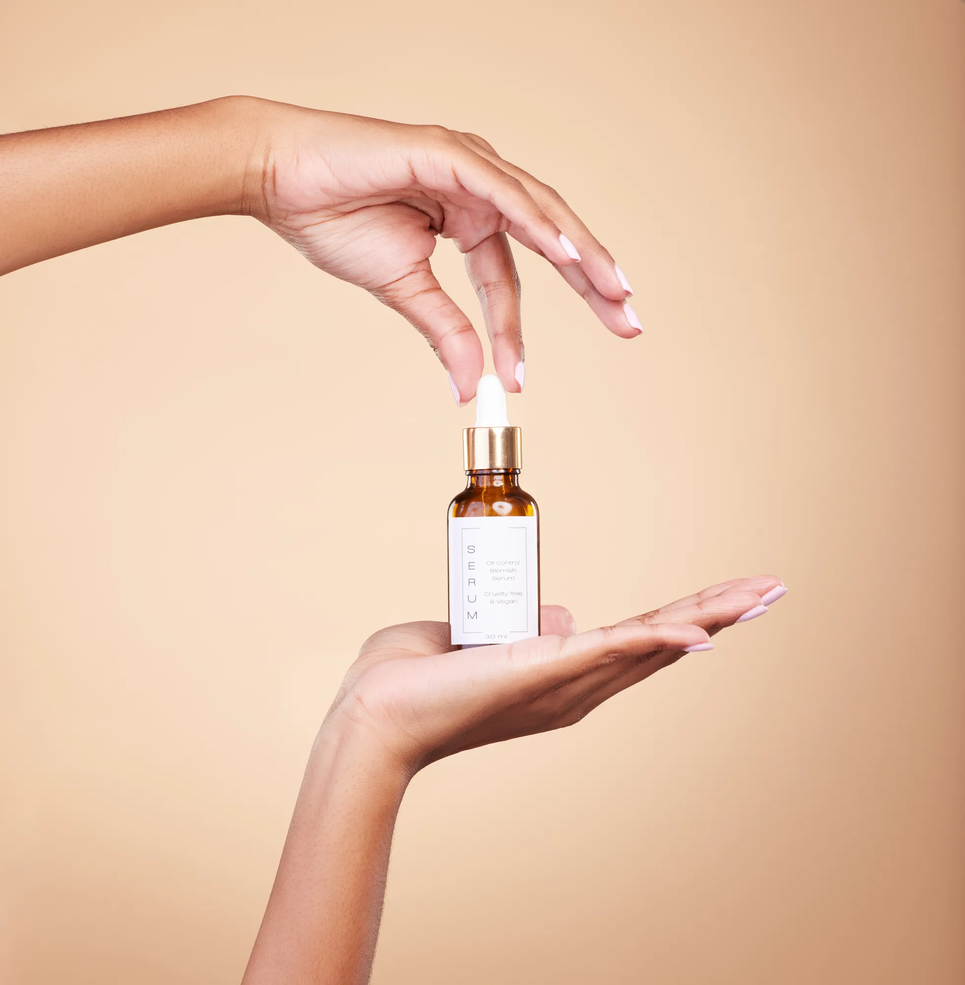 A close-up beauty shot of a facial serum being held in the air. 